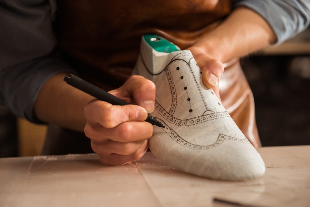 close up male shoemaker drawing design